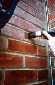 Brick stain being applied to a wall